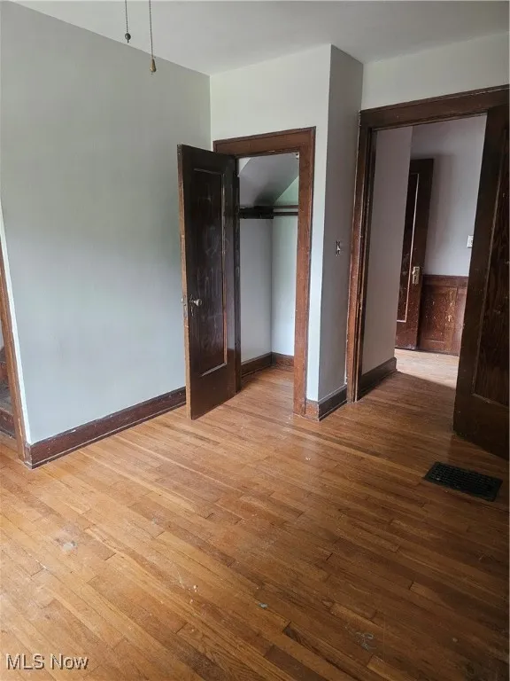 Unfurnished bedroom featuring a closet and hardwood / wood-style flooring