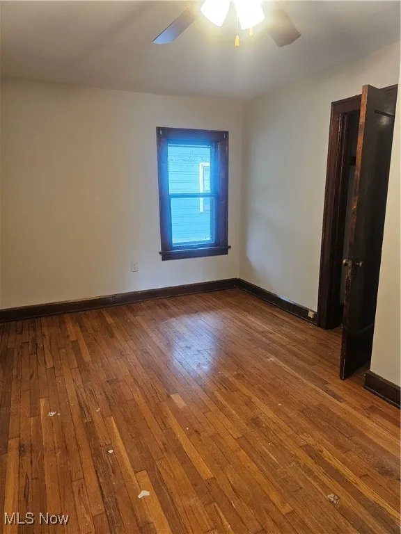 Empty room with ceiling fan and wood-type flooring