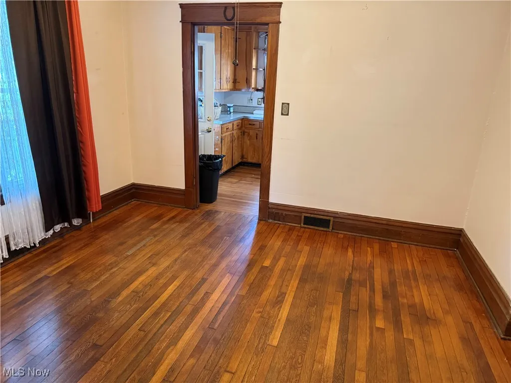 Empty room featuring dark wood finished floors