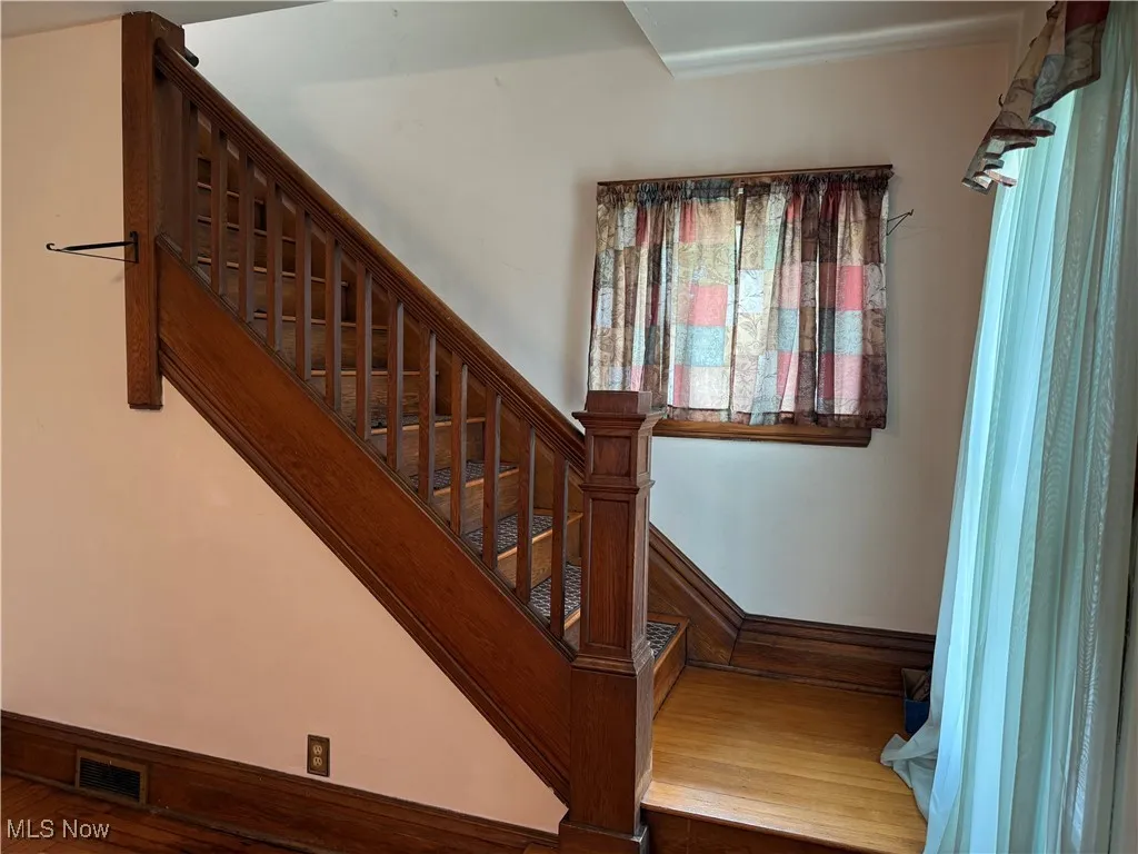 Stairs featuring wood finished floors