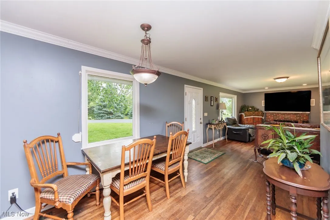 Dining area with wood finished floors, healthy amount of natural light, crown molding, and baseboards