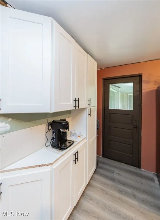 Kitchen featuring white cabinetry, light countertops, and light wood-style flooring