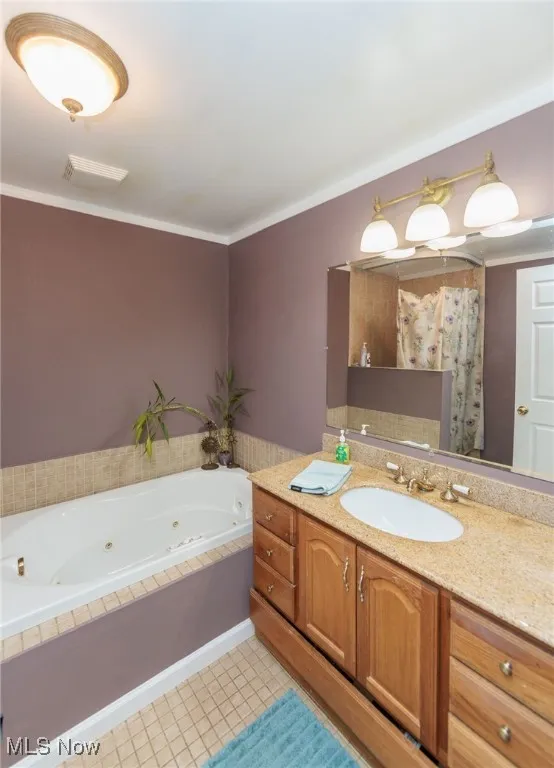 Full bath featuring a whirlpool tub, vanity, and crown molding