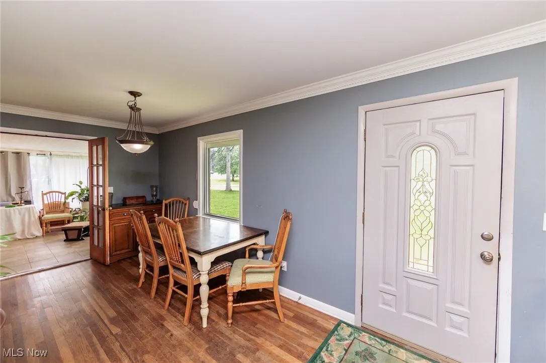 Dining area with ornamental molding, wood finished floors, and baseboards