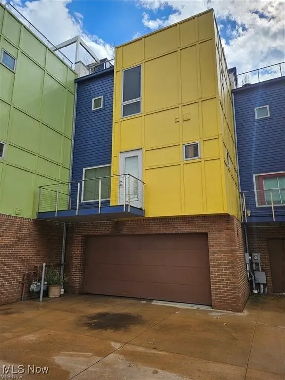 Rear view of house with a garage, brick siding, and driveway