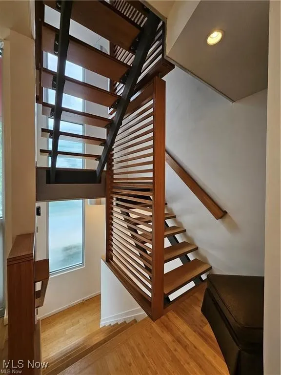 Staircase featuring wood finished floors and recessed lighting