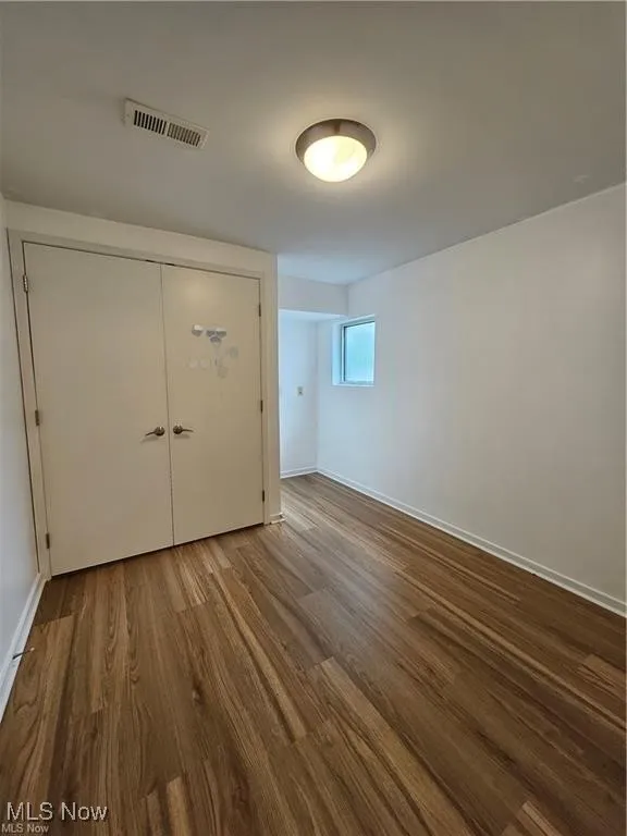 Empty room with dark wood-style floors and baseboards