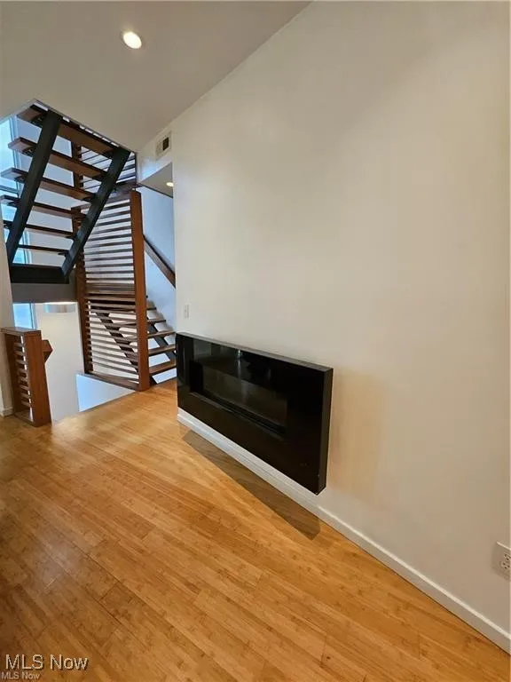 Unfurnished living room featuring light wood-style floors, baseboards, and recessed lighting