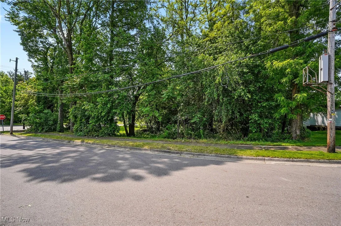 View of asphalt road featuring traffic signs and curbs