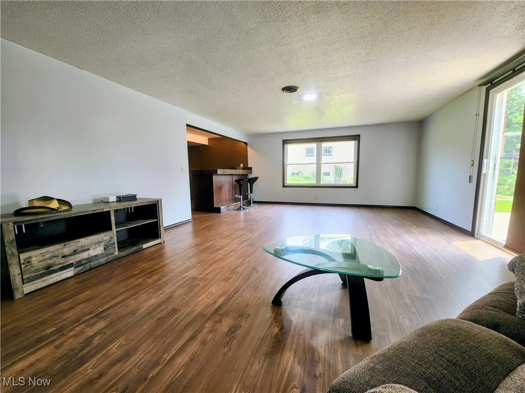Living area featuring wood finished floors and a textured ceiling
