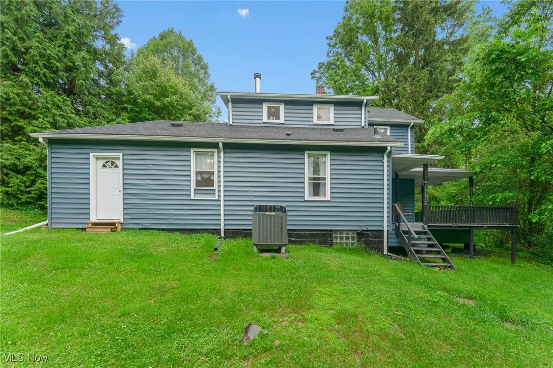 Rear view of property with a yard, a chimney, roof with shingles, and entry steps