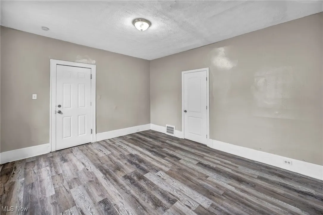 Spare room with wood finished floors and a textured ceiling