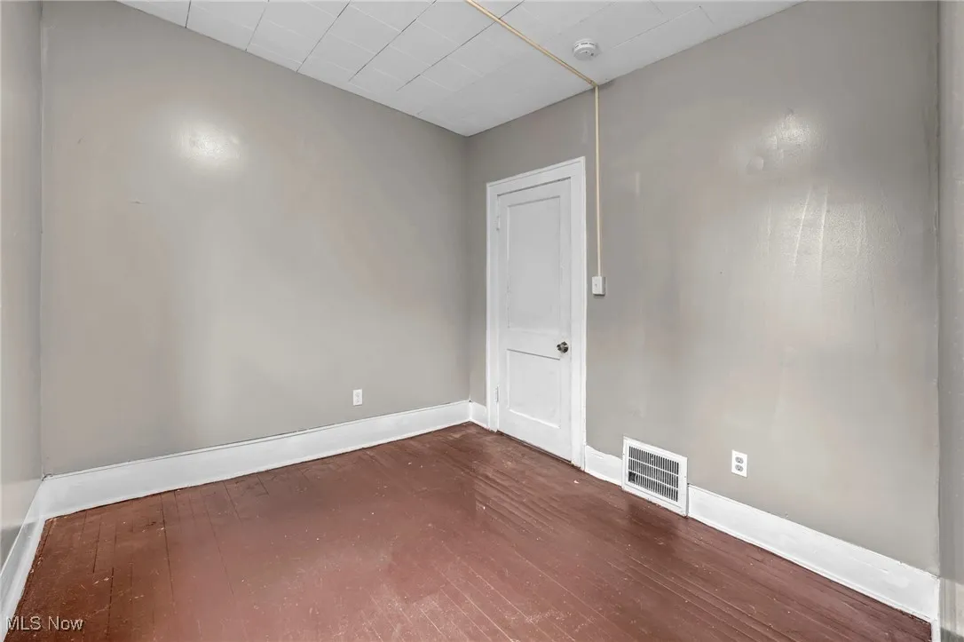 Spare room featuring dark wood-type flooring and a smoke detector