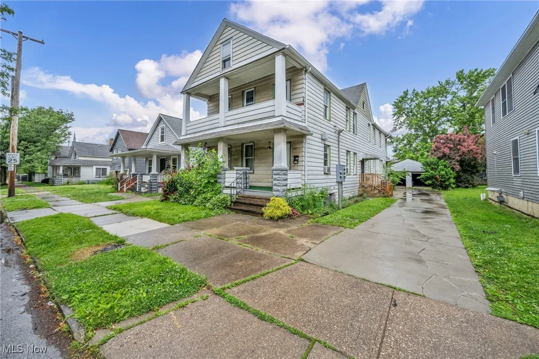 View of front of house featuring covered porch, a front yard, and driveway