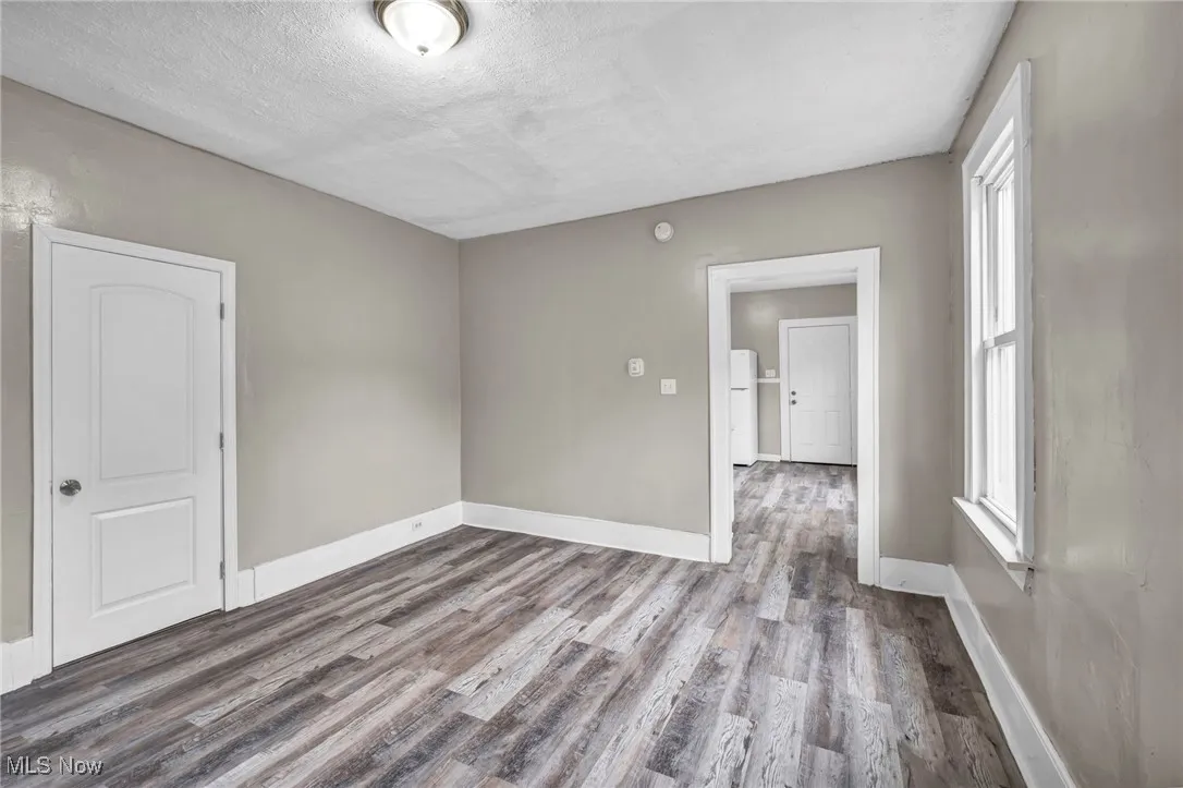 Unfurnished room with wood finished floors and a textured ceiling