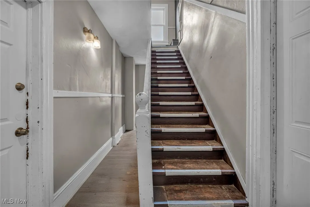 Staircase featuring baseboards and wood finished floors