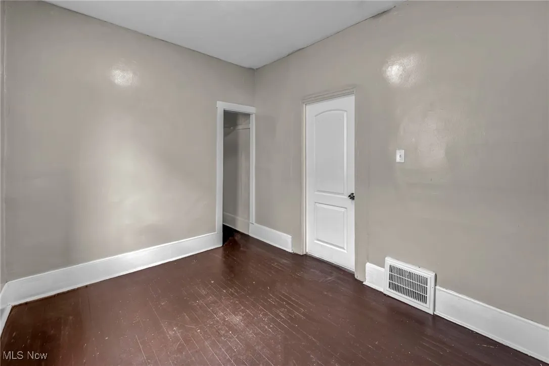 Unfurnished room with wood finished floors and baseboards