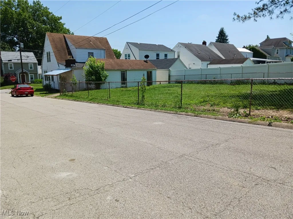 View of asphalt street featuring a residential view and traffic​​‌​​​​‌​​‌‌​‌‌​​​‌‌​‌​‌​‌​​​‌​​ signs