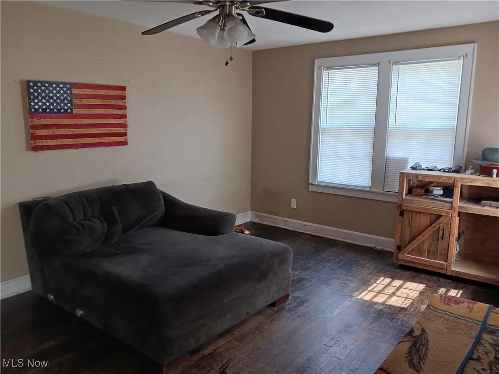 Living room with dark wood-style flooring and ceiling fan