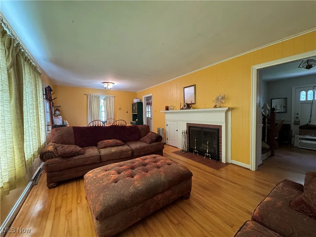 Living area with wood finished floors and a brick fireplace