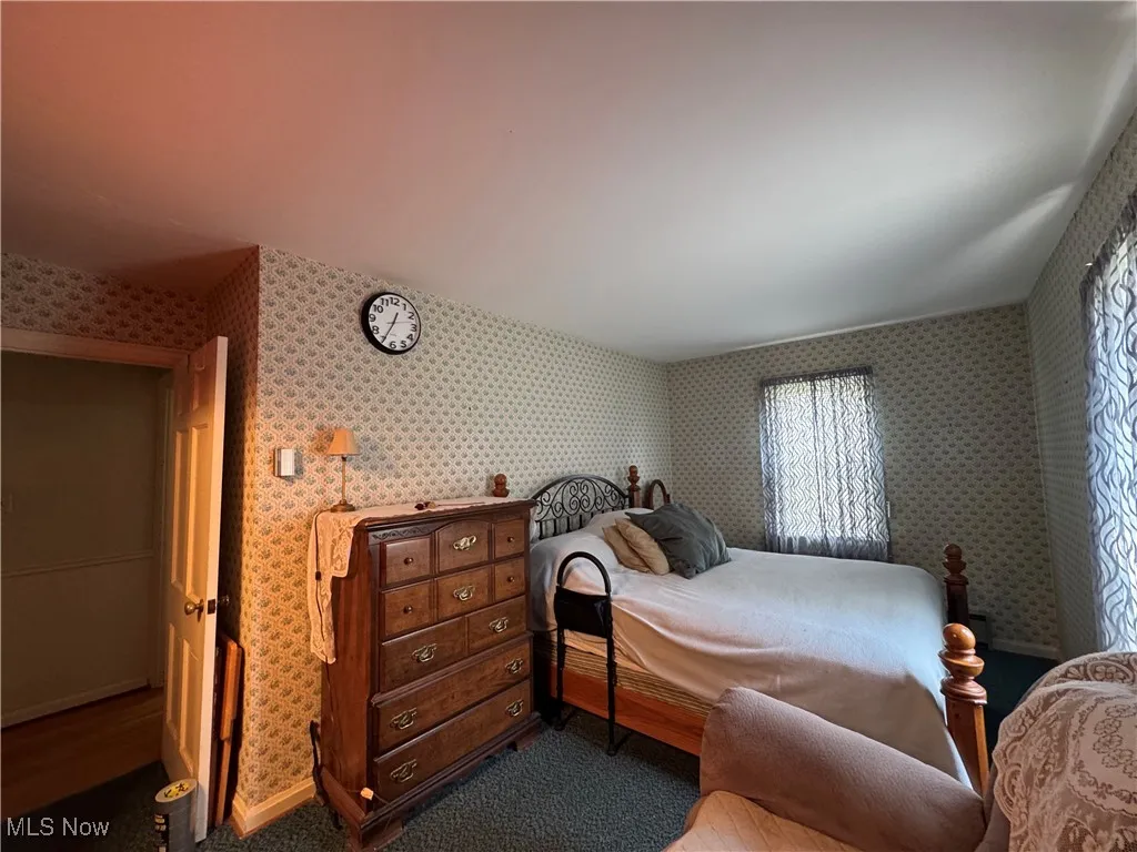 Bedroom featuring baseboards and wallpapered walls