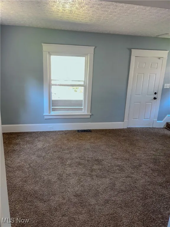 Living room with a textured ceiling and carpet