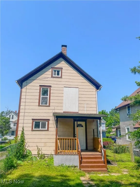 Rear view of property featuring a chimney and covered porch