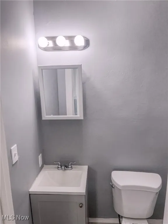 Half bathroom featuring toilet and vanity