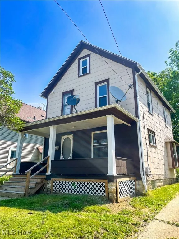 View of front facade featuring a front yard and covered porch