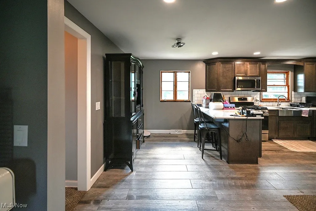 Kitchen featuring stainless steel appliances, plenty of natural light, recessed lighting, and hardwood / wood-style floors