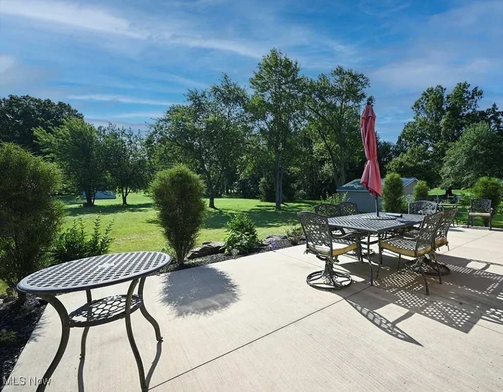 View of patio with outdoor dining space and view of scattered trees