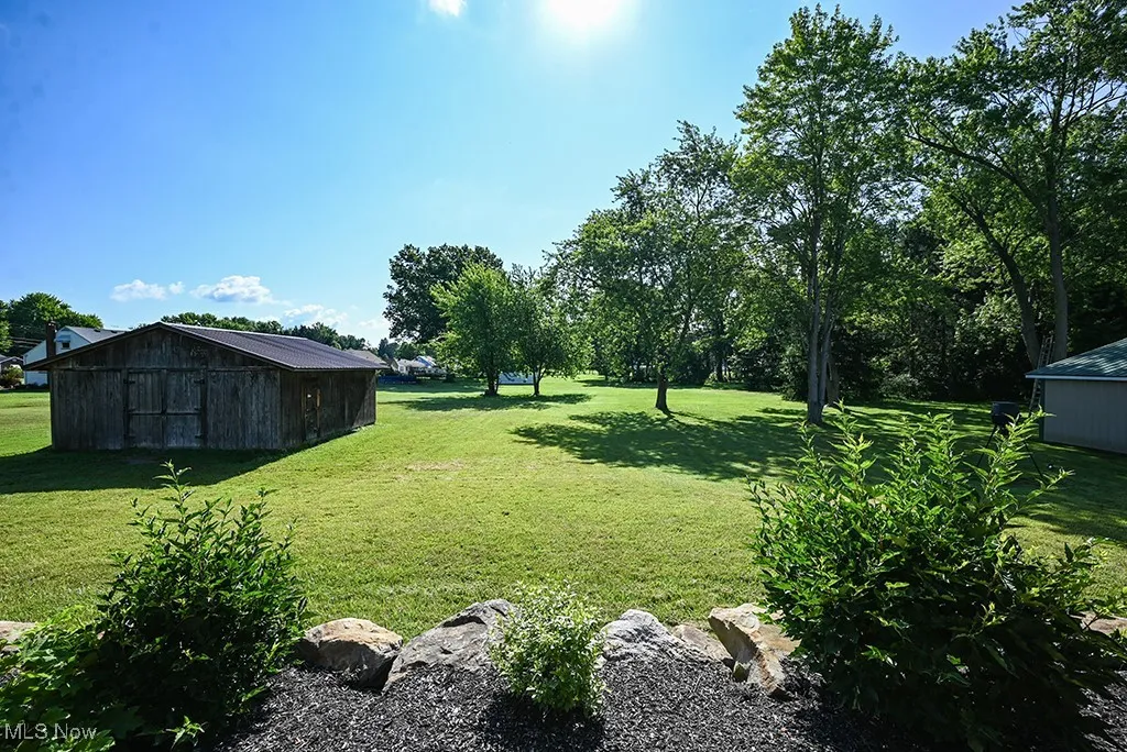 View of green lawn featuring an outdoor structure