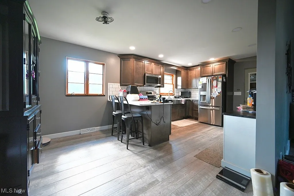 Kitchen featuring stainless steel appliances, a peninsula, a breakfast bar area, plenty of natural light, and recessed lighting