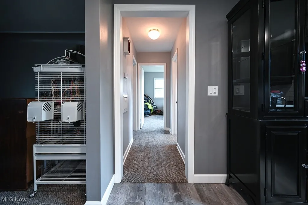 Hallway featuring wood finished floors and baseboards