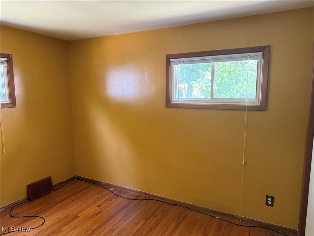 Spare room featuring light wood-style floors and baseboards