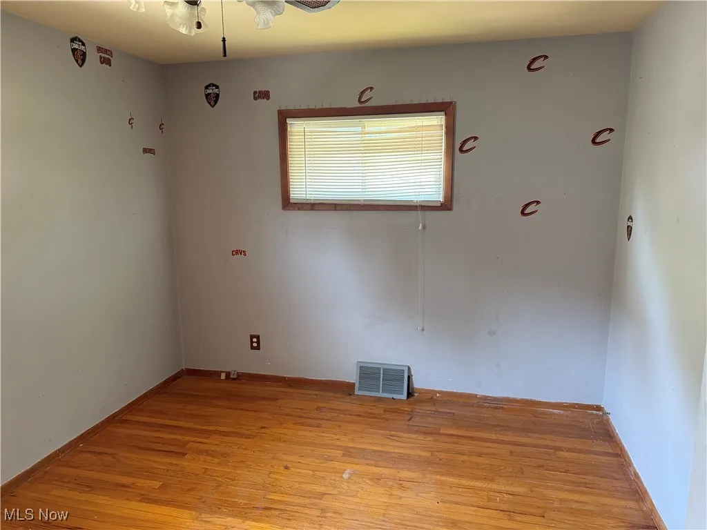 Empty room with light wood finished floors and a ceiling fan