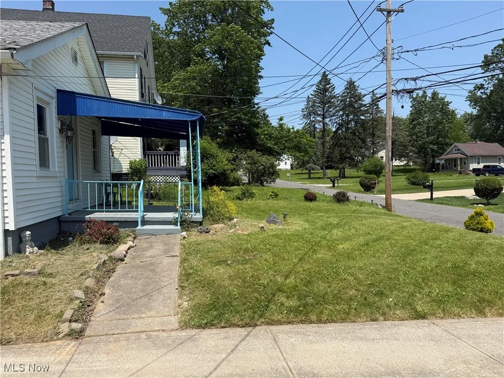 View of green lawn featuring a porch