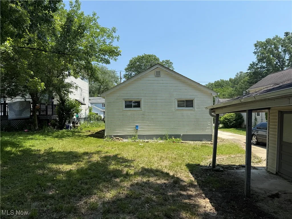 View of side of home with a yard