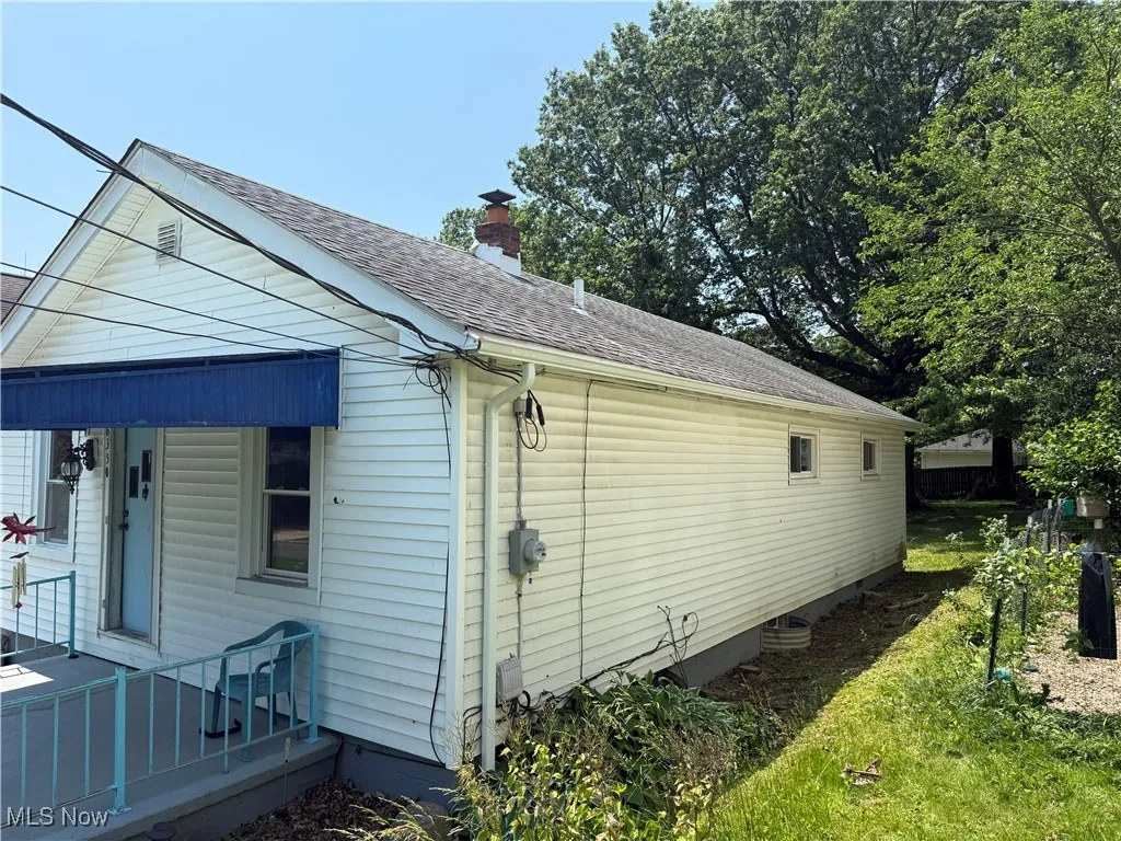 View of property exterior featuring roof with shingles and a chimney
