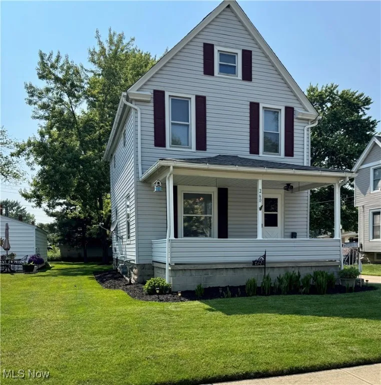 Traditional style home with a front yard and covered porch