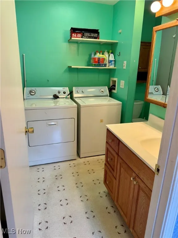 Laundry room with washer and dryer and light flooring