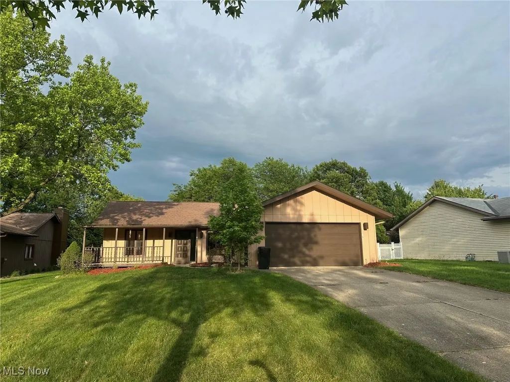 Single story home with a porch and with attached 2 car garage