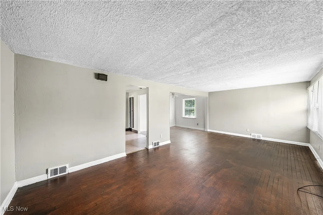 Empty room with wood finished floors and a textured ceiling