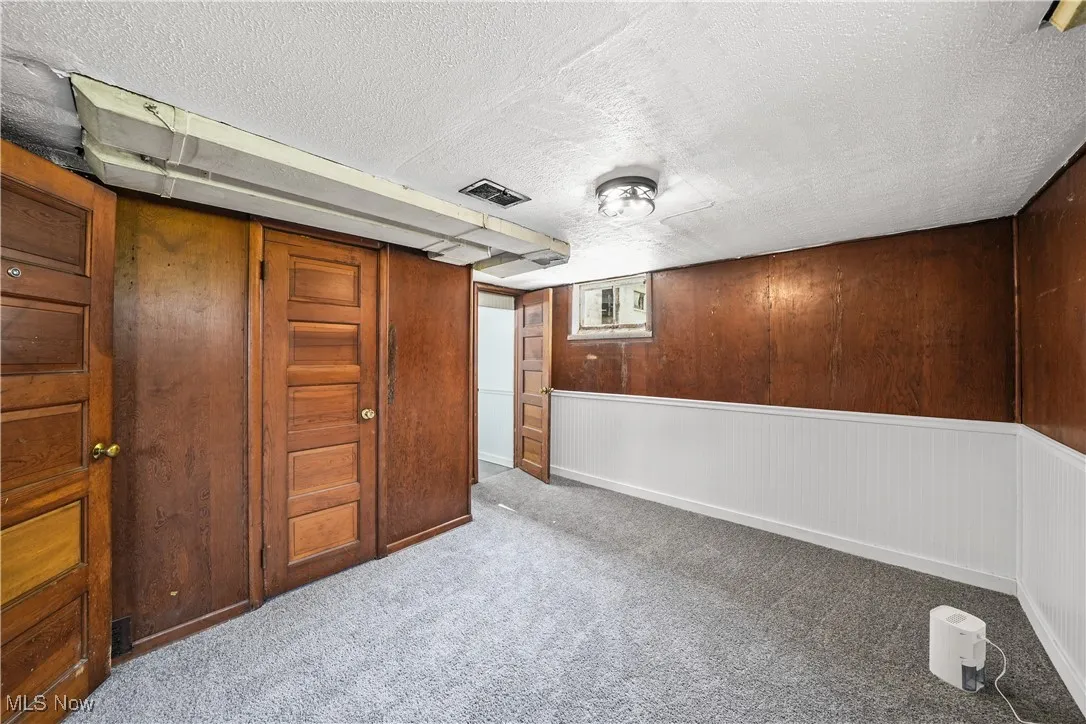 Finished basement featuring carpet and a textured ceiling