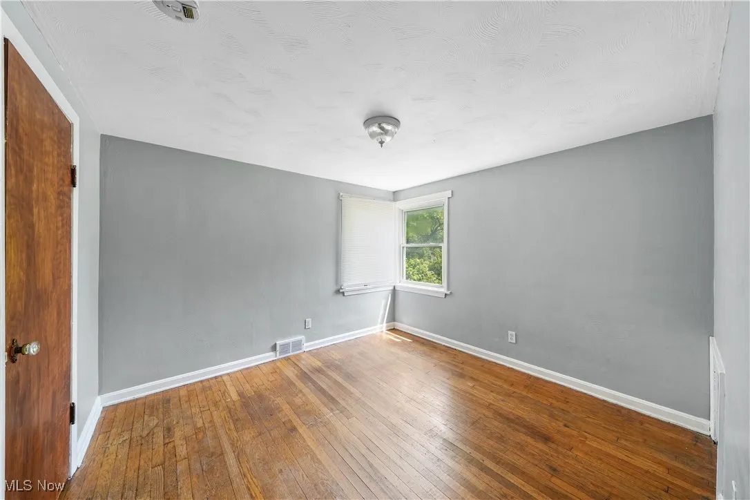 Empty room featuring wood-type flooring and baseboards