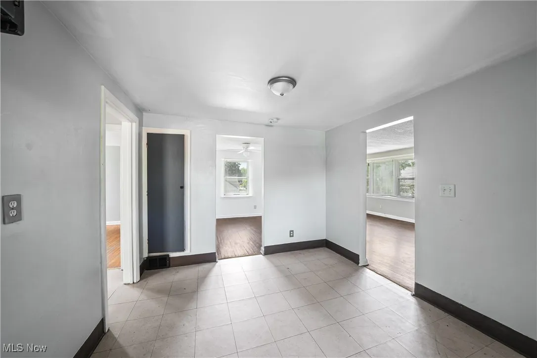 Unfurnished room featuring plenty of natural light, a ceiling fan, and light tile patterned floors
