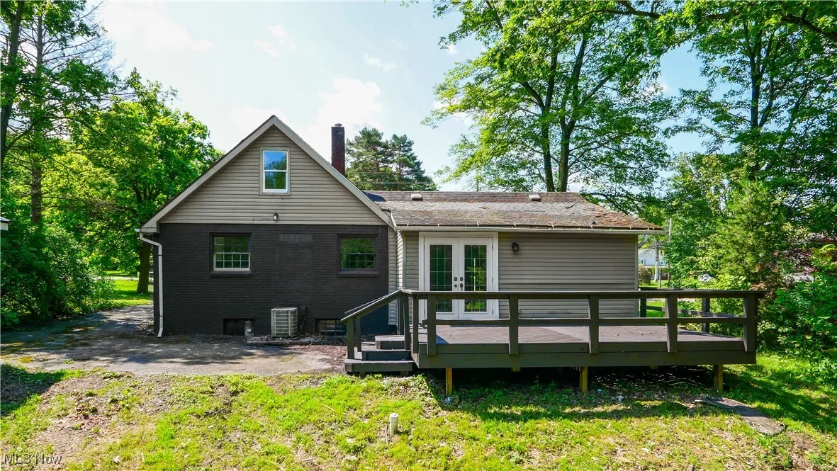 Rear view of house featuring french doors, a wooden deck, a chimney, and brick siding