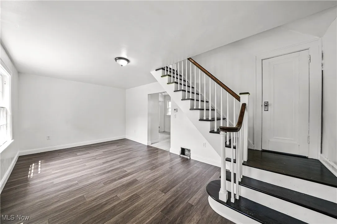 Stairway with wood finished floors and baseboards