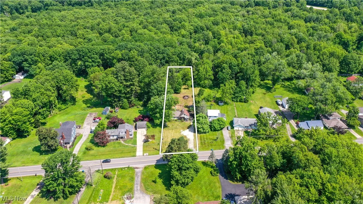 Aerial view of property's location featuring a heavily wooded area and property boundaries highlighted
