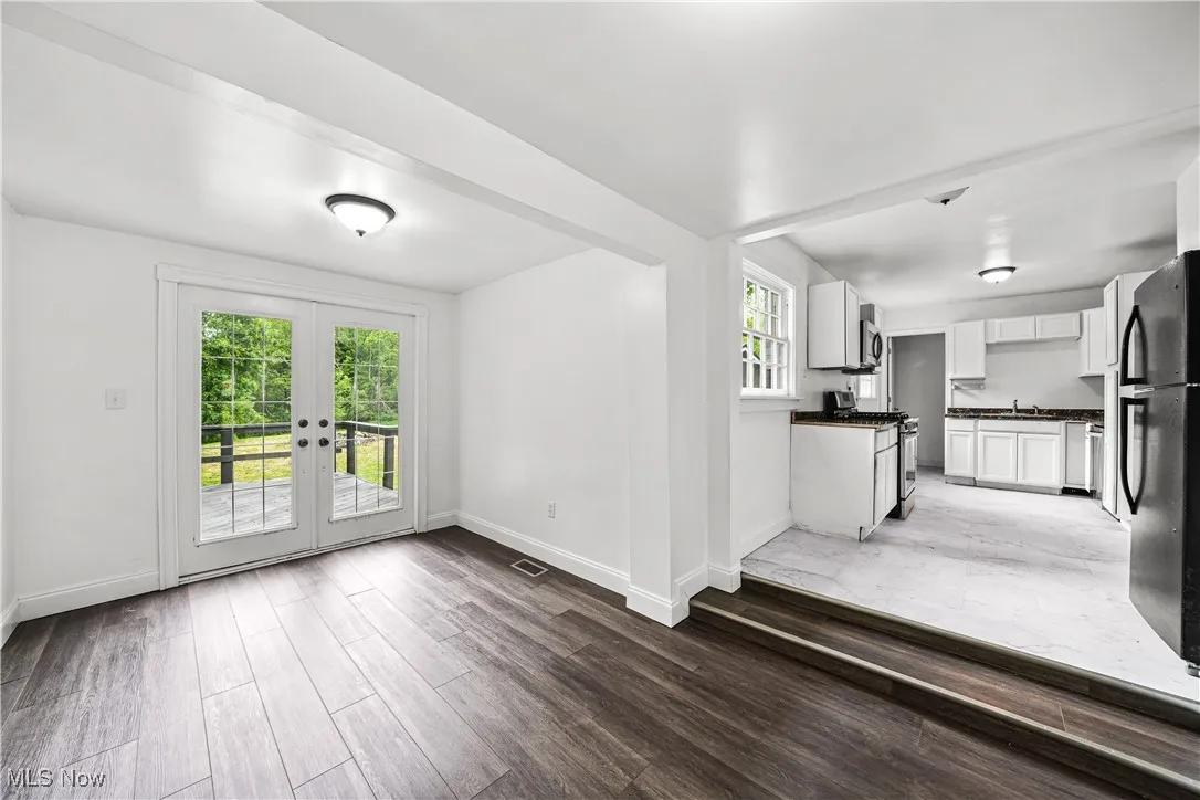 Unfurnished living room featuring light wood-style flooring and french doors